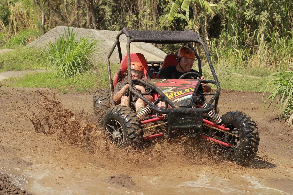 Tandem buggy riders making a muddy turn