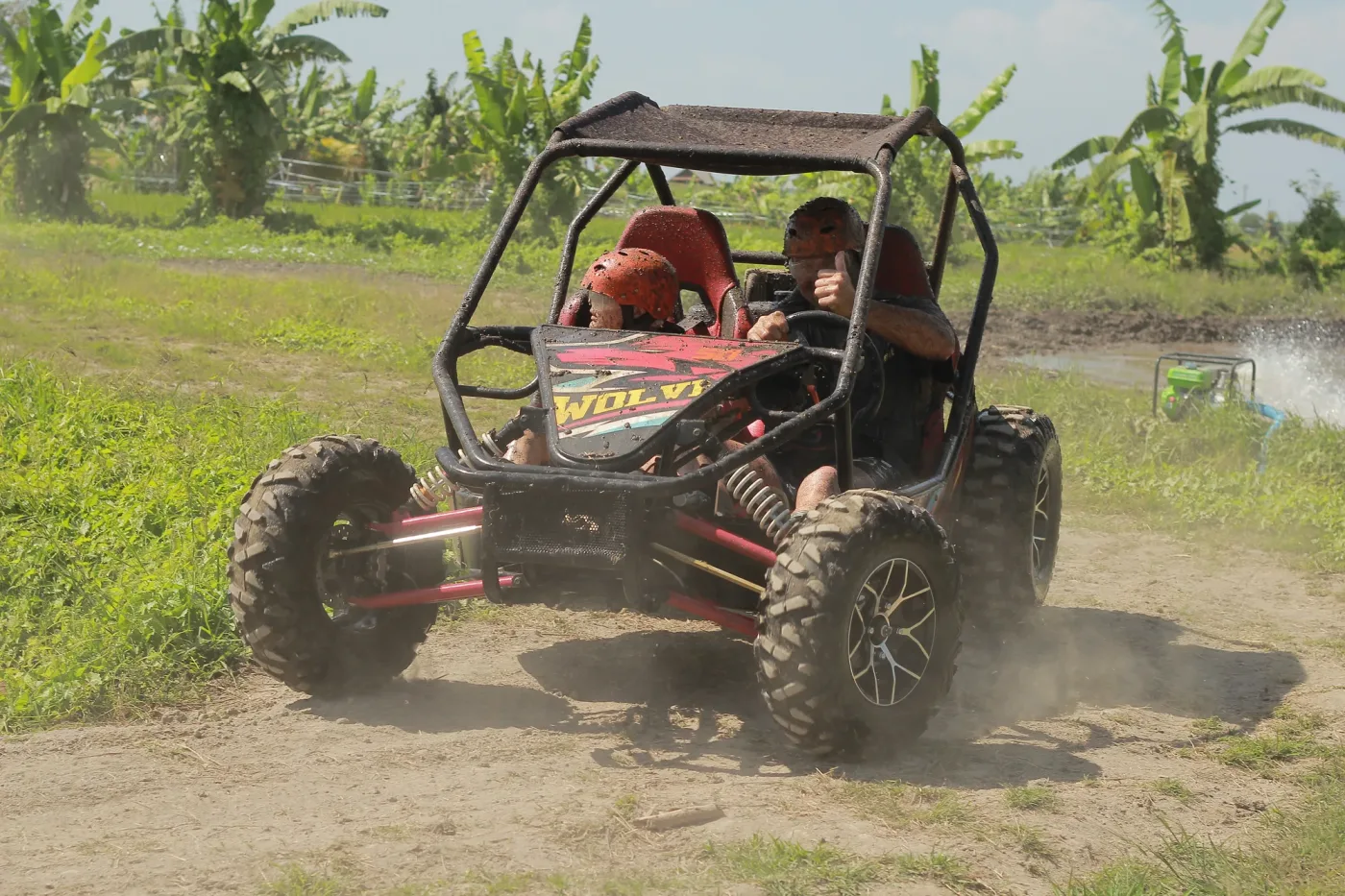 Buggy moving through dust on a tropical off-road track