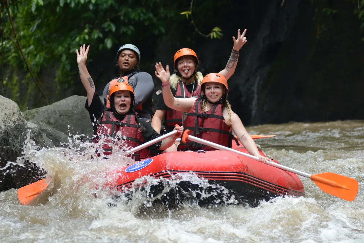 Rafting team navigating river rapids